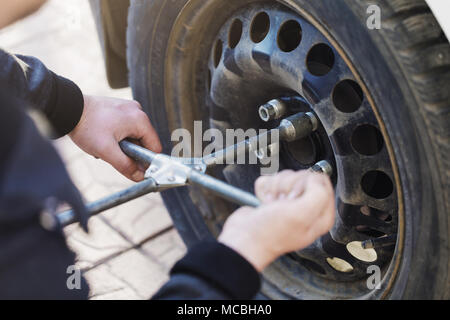Process of unscrewing the car wheel and replacing the winter tires for summer Stock Photo