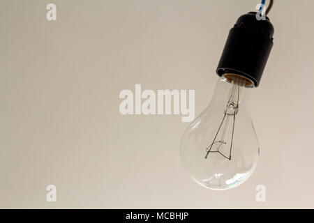 Close up picture of isolated electric light bulb on gray abstract background. Energy saving and economy concept. Stock Photo