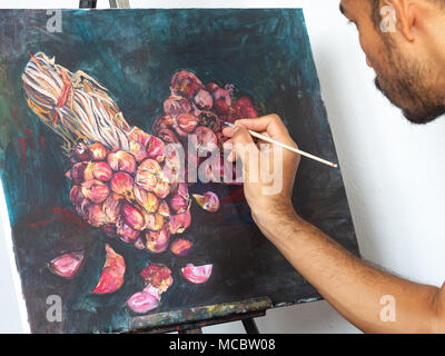 Closeup male artist painting red shallot, acrylic color on canvas Stock Photo