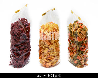 Dried three pasta in bag front view. Colorful vegetable pastas on isolated background Stock Photo