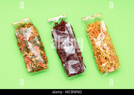 Dried three pasta in bag front view. Colorful vegetable pastas on isolated background Stock Photo