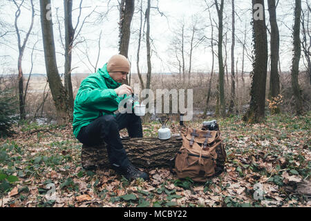 Man with backpack in wild forest Stock Photo