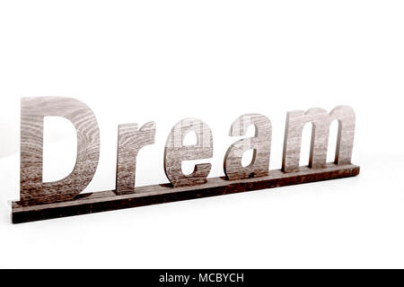 The word „dream“ in wooden letters - isolated in front of a white wall; das Wort “dream” in Holzbuchstaben vor einer weißen Wand Stock Photo