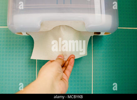women's hand pulls out a paper napkin from the tray. Stock Photo