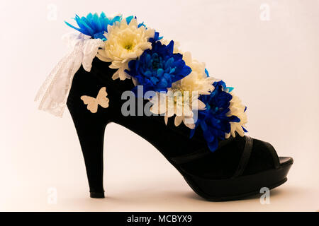 Flowers in a romantic gift box. Blue and white chrysanthemums in women shoe. Isolated on white Stock Photo