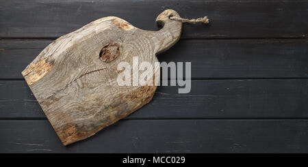 Distressed wooden serving board on dark background. Food display mock up background Stock Photo