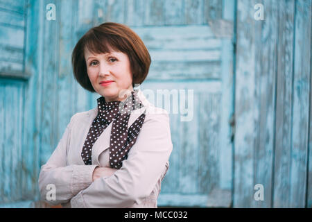 Close Up Portrait Adult Beautiful Woman Looks At Camera On Old Blue Wooden Wall Background Stock Photo