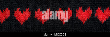 Knitted red hearts banner made of yarn on a black background. Stock Photo