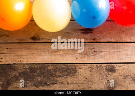 Colourful balloons on wooden table. Copy space.