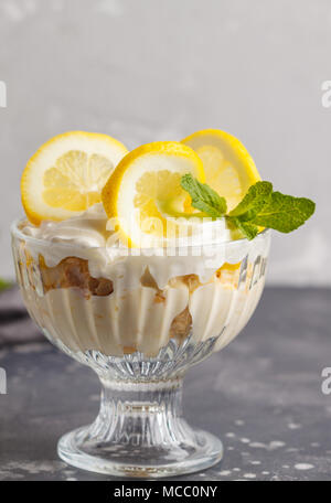 Lemon dessert, lemon trifle, cheesecake, whipped cream, parfait. Fruit mousse in glass on a light background. Stock Photo