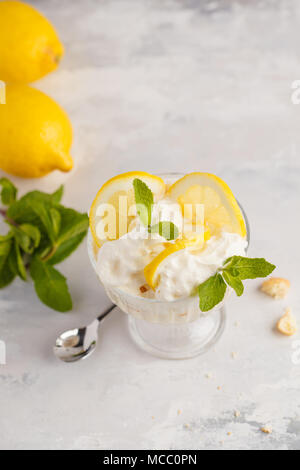 Lemon dessert, lemon trifle, cheesecake, whipped cream, parfait. Fruit mousse in glass on a light background. Stock Photo