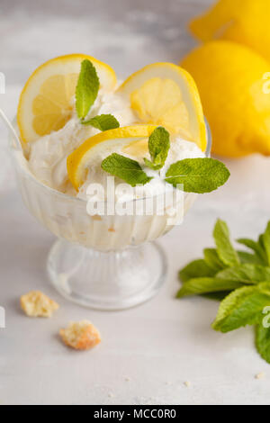 Lemon dessert, lemon trifle, cheesecake, whipped cream, parfait. Fruit mousse in glass on a light background. Stock Photo