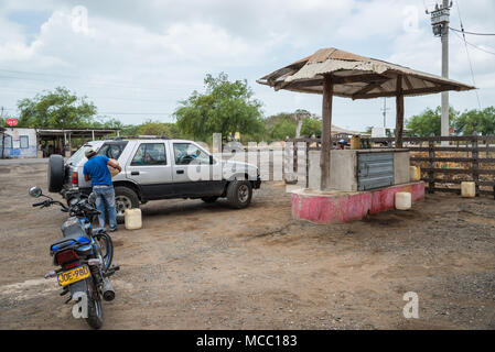 A man fills up gasoline for a car at a rural petro station. Colombia, South America. Stock Photo