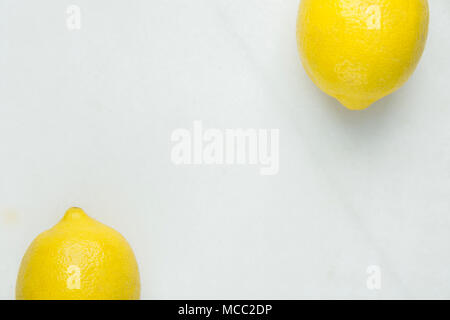 Two Ripe Organic Lemons Arranged in Top and Bottom Border on White Marble Stone Background. Summer Vitamins Healthy Lifestyle Superfoods Concept. Food Stock Photo