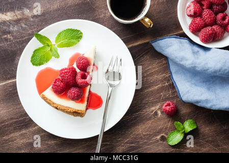 Cheesecake with raspberries and berry sauce on wooden table. Top view, selective focus Stock Photo