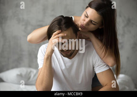 Caring woman embracing upset offended man trying to make peace cheer him up, loving wife apologizing resentful husband after conflict excusing asking  Stock Photo
