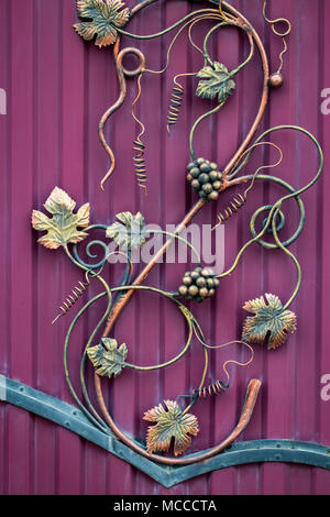 Forged bunch of grapes. ornate wrought-iron elements of metal gate decoration. Stock Photo