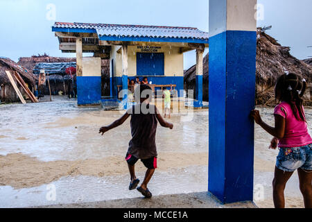 Guna Yala, Panama - march 2018: Group of children playing on the street in a Kuna Village on a rainy day Stock Photo