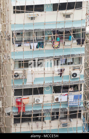 Builders repairing a building using traditional Indian wooden scaffolding made out of wood poles tied together with rope, Malabar, Mumbai, India Stock Photo