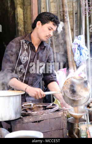 A man pouring masala chai (Indian tea) at a tea stall on Nagdevi street near Crawford market, Mumbai Stock Photo