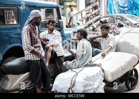 Market traders talking together on a work break, Nagdevi street near Crawford market, Mumbai Stock Photo