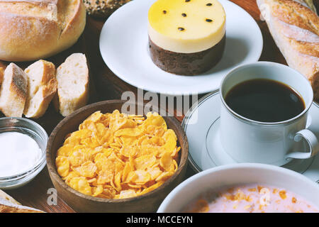 Close up of passion fruit cake, toast, coffee, yogurt, cereals. Continental breakfast Stock Photo