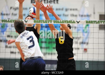 Player delivering a kill shot past a pair of opponents at the net. USA. Stock Photo