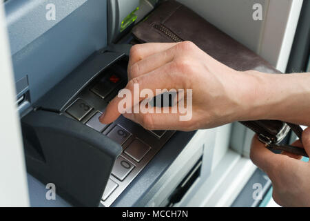 female hand entering a secure PIN code at a cash point or ATM up close and in detail Stock Photo