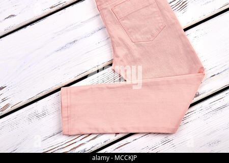 Teen girls modern summer trousers. Female slim peach color pants on white  wooden background, copy space. Woman summer fashion outfit Stock Photo -  Alamy