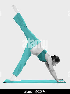 Pregnant woman making exercise, isolated on white Stock Photo