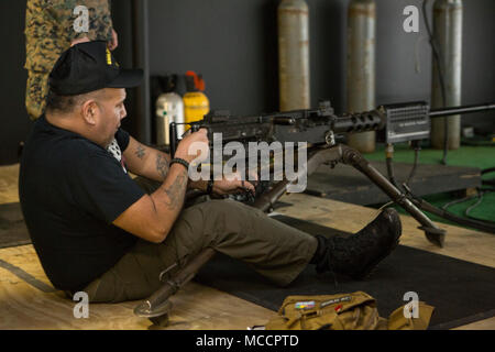 A member of the Second Marine Division Association (SMDA) sights in using an M2 .50 Caliber machine gun on a simulated target inside of the Division Combat Skills Center on Camp Lejeune, N.C., Feb. 8, 2018. The SMDA is aboard Camp Lejeune to celebrate the 2nd Marine Division’s 77th anniversary. (U.S. Marine Corps photo by Lance Cpl. Christian J. Robertson) Stock Photo