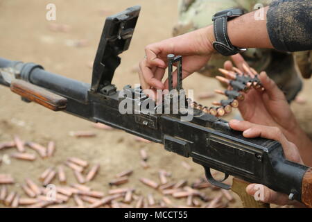 An Iraqi soldier load a belt of ammunition into a PKC machine gun ...