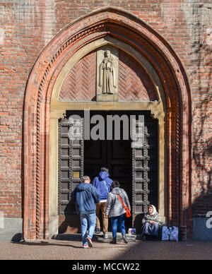 Milan, Italy - April 1st, 2018: An elderly woman beggar who appears to be a Roma Gypsie begging in front of a church in Milan Stock Photo