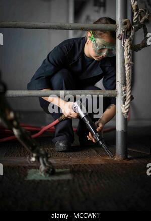 180212-N-NG033-1015 ARABIAN GULF (Feb. 12, 2018) Seaman Yumi Wilson strips paint from the deck aboard the aircraft carrier USS Theodore Roosevelt (CVN 71). Theodore Roosevelt and its carrier strike group are deployed to the U.S. 5th Fleet area of operations in support of maritime security operations to reassure allies and partners and preserve the freedom of navigation and the free flow of commerce in the region. (U.S. Navy photo by Mass Communication Specialist Seaman Michael Hogan/Released) Stock Photo