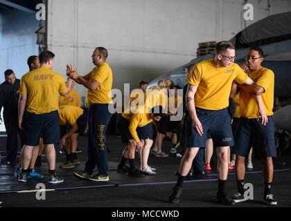 180212-N-NG033-1189 ARABIAN GULF (Feb. 12, 2018) Sailors conduct hand-to-hand combat training in the hangar bay of the aircraft carrier USS Theodore Roosevelt (CVN 71). Theodore Roosevelt and its carrier strike group are deployed to the U.S. 5th Fleet area of operations in support of maritime security operations to reassure allies and partners and preserve the freedom of navigation and the free flow of commerce in the region. (U.S. Navy photo by Mass Communication Specialist Seaman Michael Hogan/Released) Stock Photo