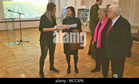 Sylwia Pindor (left) public affairs officer linguist to Battle Group Poland reviews a prepared speech with Andrea Bekić, the Croatian Ambassador to Poland, during a Croatian cultural celebration at the Polish 15th Mechanized Brigade headquarters Giżycko, Poland, Feb. 12, 2018. The celebration allowed the ambassador to express gratitude to Polish leaders and share Croatian culture with the community leaders in attendance. The unique, multinational battle group is comprised of U.S., U.K., Croatian and Romanian soldiers serve with the Polish 15th Mechanized Brigade as a deterrence force in northe Stock Photo