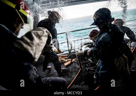 U.S. Sailors patch pipes during a damage control drill on the boat deck of the aircraft carrier USS Theodore Roosevelt (CVN 71) in the Arabian Gulf Feb. 12, 2018. The Theodore Roosevelt and its carrier strike group are deployed to the U.S. 5th Fleet area of operations in support of maritime security operations to reassure allies and partners and preserve the freedom of navigation and the free flow of commerce in the region. (U.S. Navy photo by Mass Communication Specialist Seaman Apprentice Bill M. Sanders) Stock Photo