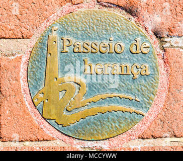 decorative metal sidewalk disc in Spanish language along Baltimore's Heritage Walk historical walking trail Stock Photo