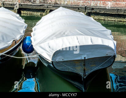 2 small sailboats covered with tarps near a brick and timber wharf in Baltimore's Inner Harbor Stock Photo