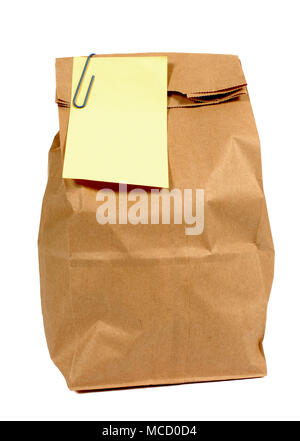 Brown paper lunch or groceries bag with yellow post it style sticky note isolated on white Stock Photo