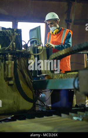 Young Worker Operating Machine Stock Photo
