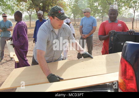 Task Force Darby soldiers of Civil Affairs Team 4032 assist village leaders as they built a roof for a school in Garoua, Cameroon near Contingency Location Garoua Feb. 10, 2018. Stock Photo