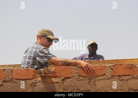 Task Force Darby soldiers of Civil Affairs Team 4032 assist village leaders as they built a roof for a school in Garoua, Cameroon near Contingency Location Garoua Feb. 10, 2018. Stock Photo