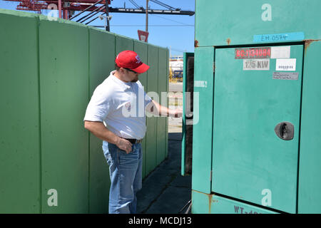 U.S. Army Corps of Engineers Temporary Power Mission Manager, Jake Ellison, inspects a non-federal power generator located at a port in Ponce, Puerto Rico on February 18, 2018.  Following the damage done by Hurricane Maria, the USACE was tasked by FEMA to provide maintain and repair privately owned generators at critical public facilities until grid-power is restored.  To date crews have repaired more than 150 generators and performed generator maintenance more than 290 times. Stock Photo