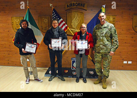 From right, U.S. Army Col. James Bartholomees III, commander of the 173rd Airborne Brigade, presenst a Certificate of Achievement to Ms. Francesca Cisotto, Mr. Graziano Gentilin, and, Mr. Maximilian Casity of the Vicenza Movement Control Team, for their contribution to the 173rd Airborne Brigade's freedom of movement throughout Italy and Europe, Caserma Del Din, 15 Feb. 2018, Vicenza, Italy. (U.S. Army Photo by Paolo Bovo) Stock Photo