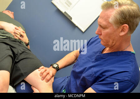 Naval Hospital Jacksonville is a United States Navy medical treatment facility in Jacksonville, Florida. The Navy Medical Corps, founded in 1871, includes surgeons who support operational and clinical missions. The archival image documents a Captain serving as an orthopedic surgeon evaluating a knee condition on Feb. 16, 2018. Stock Photo