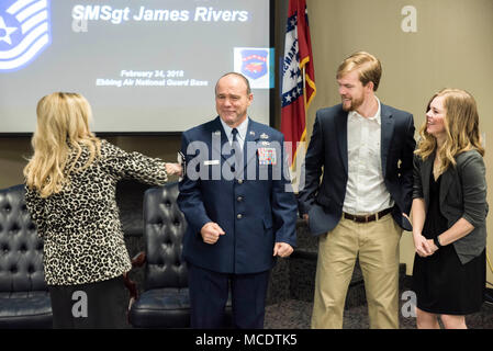 James W. Rivers, 123rd Intelligence Squadron Superintendent, braces as family members tack on stripes during his Chief Master Sgt. Promotion at Ebbing Air National Guard Base, Fort Smith, Ark., Feb. 24, 2018.  Rivers enlisted in the Air Force in July, 1986, and has served vital roles in the intelligence community in both Active Duty and the Air National Guard. (U.S. Air National Guard photo by Senior Airman Matthew Matlock) Stock Photo