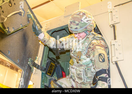 Mississippi Army National Guard Private 1st Class Elizabeth Smith, a geospatial engineer assigned to Headquarters Company, 155th Armored Brigade Combat Team, exits a high mobility multi-purpose wheeled vehicle, or HMMWV, as part of an HMMWV Egress Assistance Training exercise at the Camp Shelby Joint Forces Training Center, just South of Hattiesburg, Miss., Feb. 24, 2018. HEAT exercises train Soldiers on proper vehicle exiting procedures in the event of a rollover. (U.S. Army National Guard photo by Spc. Jovi Prevot) Stock Photo