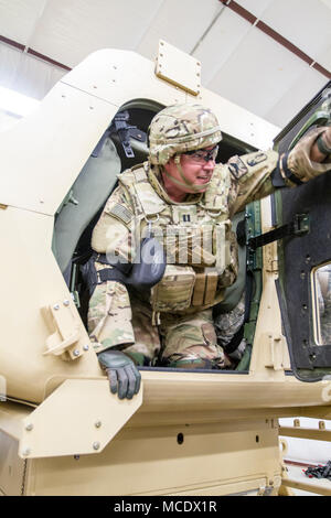 Mississippi Army National Guard Capt. Matthew D. McCann, an aviation officer assigned to Headquarters Company, 155th Armored Brigade Combat Team, exits a high mobility multi-purpose wheeled vehicle, or HMMWV, as part of an HMMWV Egress Assistance Training exercise at the Camp Shelby Joint Forces Training Center, just South of Hattiesburg, Miss., Feb. 24, 2018. HEAT exercises train Soldiers on proper vehicle exiting procedures in the event of a rollover. (U.S. Army National Guard photo by Spc. Jovi Prevot) Stock Photo