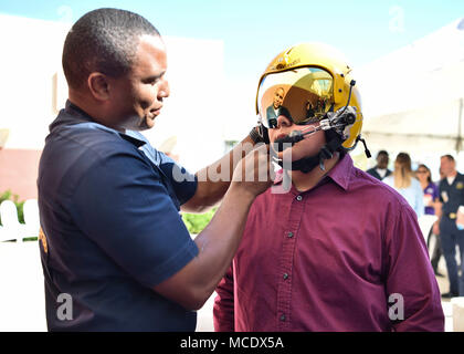 180225-N-ZC358-081  EL CENTRO, Calif. (Feb. 25, 2018) Aviation Ordnanceman, Roderick Stevenson, shows a young fan a pilot's helmet at El Centro Regional Medical Hospital during a meet and greet event. The Blue Angels are scheduled to perform more than 60 demonstrations at more than 30 locations across the U.S. in 2018. (U.S. Navy photo by Mass Communication Specialist 2nd Class Jess Gray/Released) Stock Photo